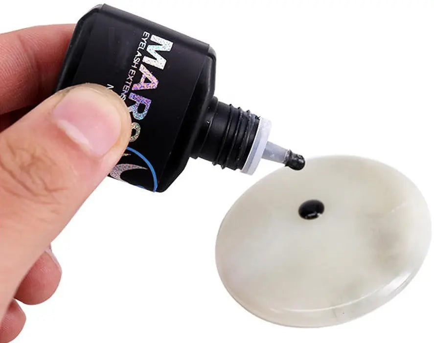 Professional applying eyelash extension glue to lashes with precision